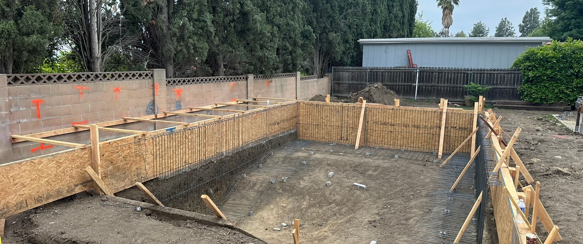 Arnwood — pool excavation with formwork laid out across the yard, under construction